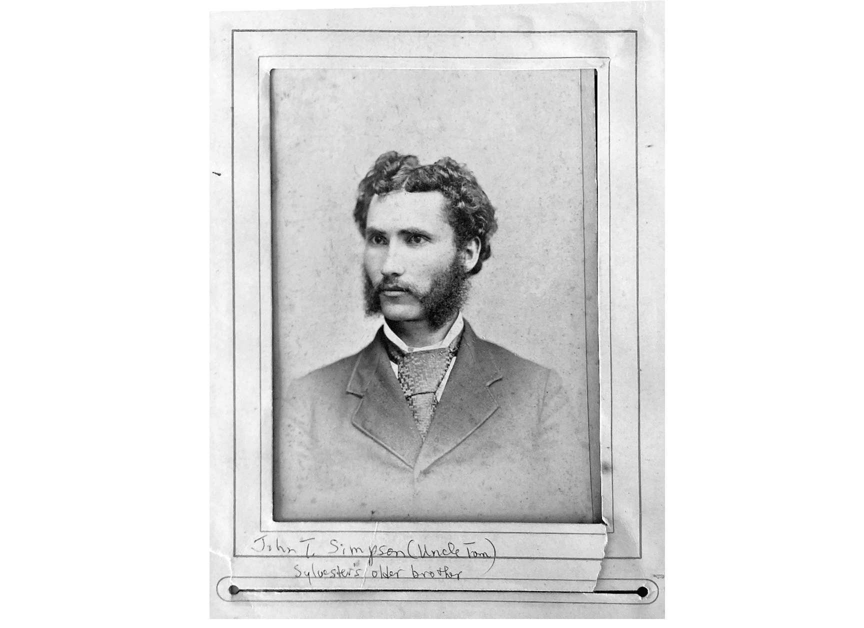 A vintage black and white portrait of an adult with curly hair and distinctive sideburns wearing a suit and tie. Description generated by AI